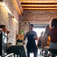 Serveur en tablier dans un bar animé