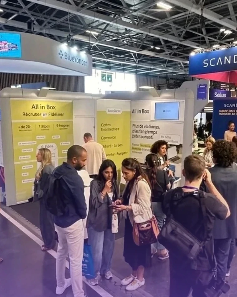 Visiteurs en discussion devant le stand All in Box, dans les allées de la NRF Europe 2026