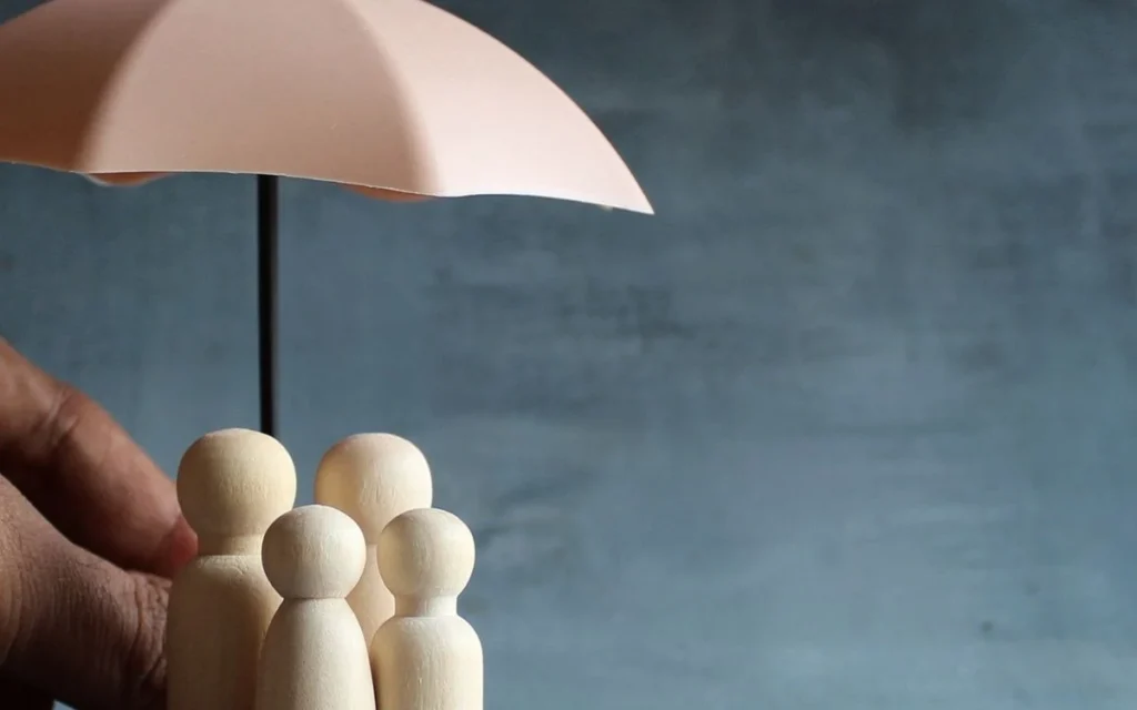 Quatre figurines en bois protégées par un parapluie, image du guide sur la sécurité des données
