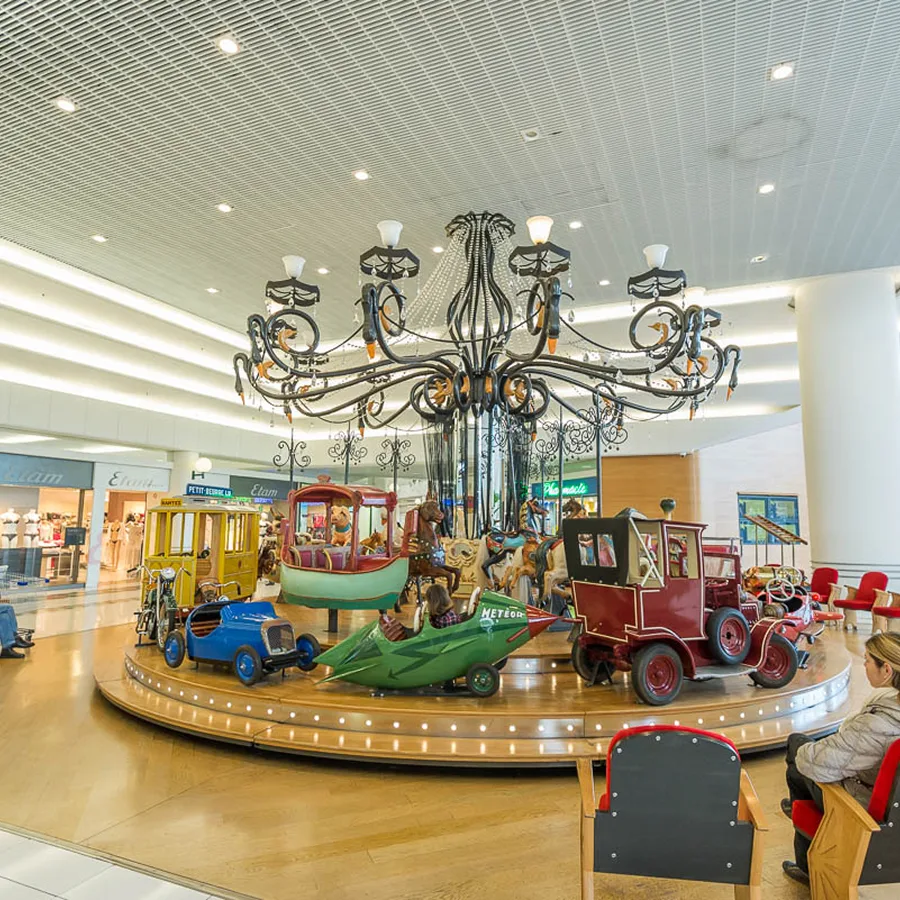 Manège d’enfants sous le lustre d’une galerie marchande